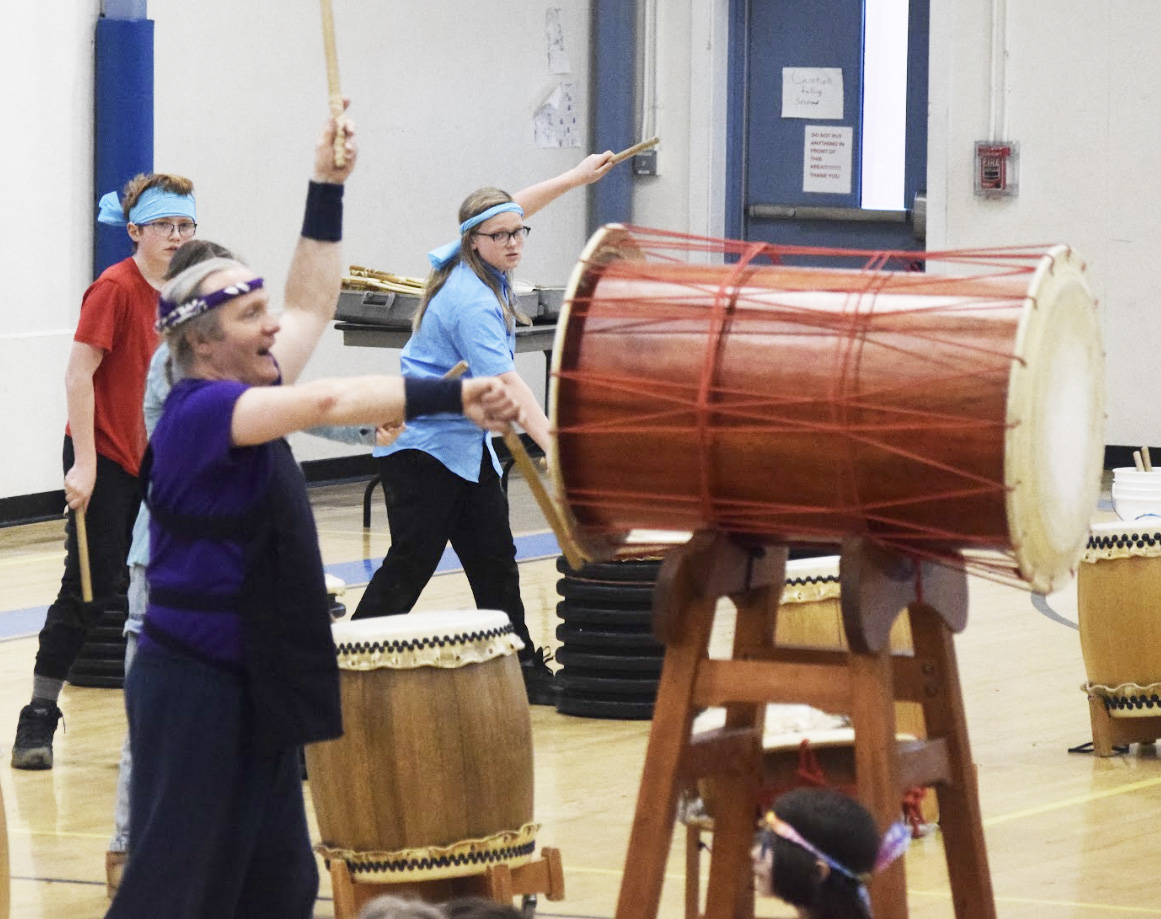 Students with Sensei playing drums